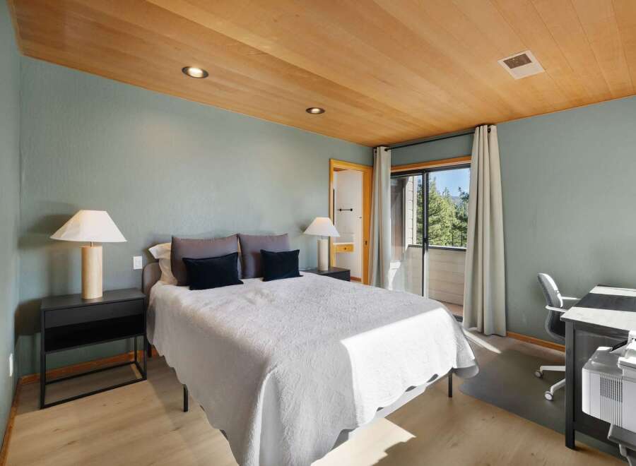 This inviting bedroom features a comfortable queen-size bed adorned with plush pillows and a textured white quilt.