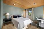 This inviting bedroom features a comfortable queen-size bed adorned with plush pillows and a textured white quilt.