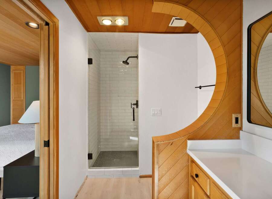 Step into a beautifully designed bathroom featuring a modern glass-enclosed shower with white subway tiles and a sleek black showerhead.