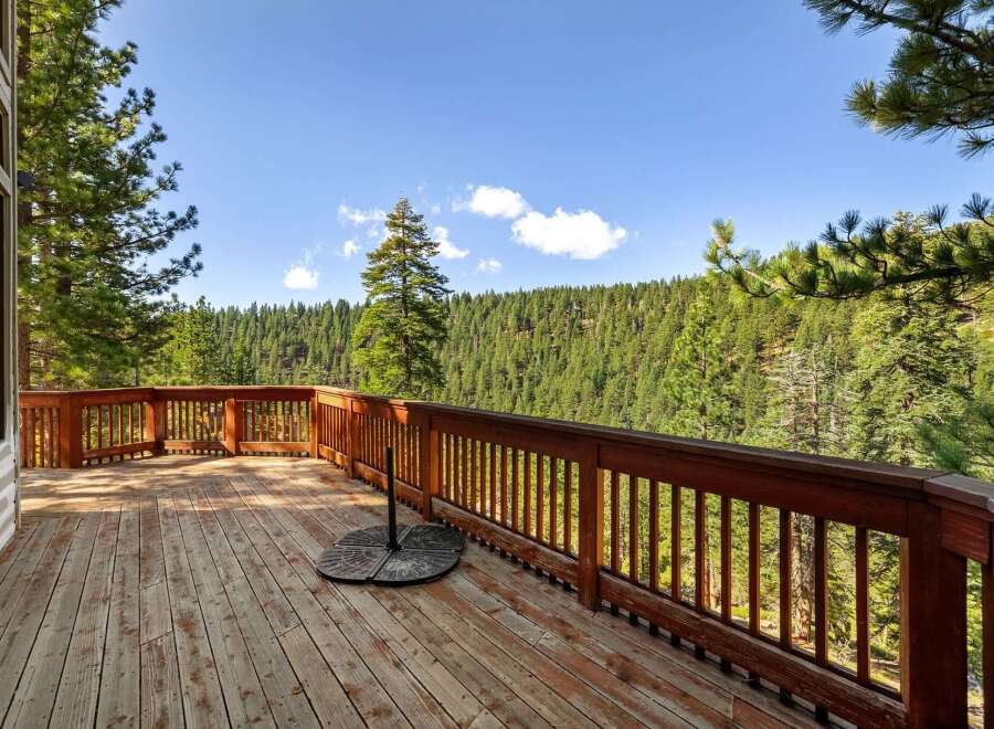 Enjoy breathtaking panoramic views from this expansive wooden deck, perfect for outdoor entertaining or quiet relaxation.
