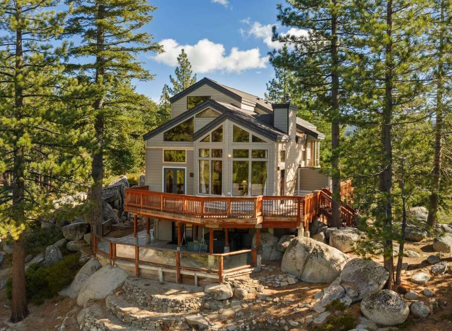 Nestled amidst towering pine trees and large granite boulders, this stunning mountain home offers breathtaking views and a serene escape.