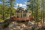 Nestled amidst towering pine trees and large granite boulders, this stunning mountain home offers breathtaking views and a serene escape.
