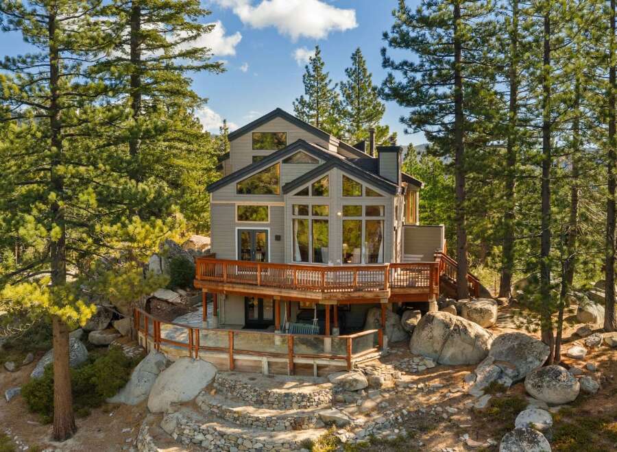 Nestled amidst towering pine trees and surrounded by natural boulders, this stunning multi-level home offers breathtaking views.