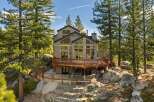Nestled amidst towering pine trees and surrounded by natural boulders, this stunning multi-level home offers a serene mountain retreat.