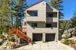 This stunning multi-story home offers a modern aesthetic with its light-colored siding and dark-trimmed windows.