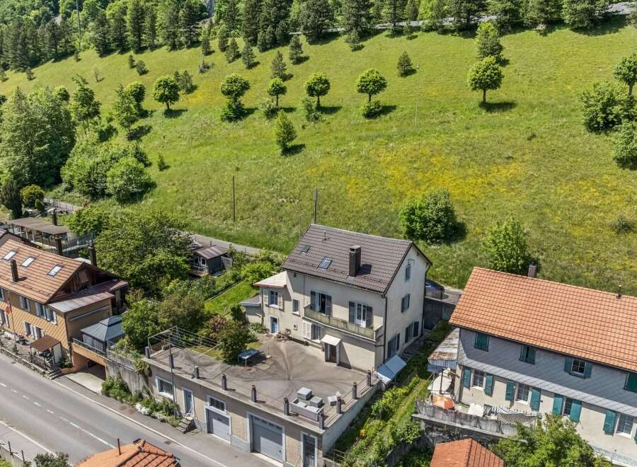Discover this charming property nestled against a lush green hillside, offering a serene retreat.