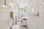This bright and airy bathroom features a modern shower enclosure with a decorative floral curtain.