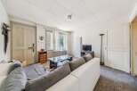 This living room features a comfortable white sectional sofa with grey cushions, perfect for relaxing.