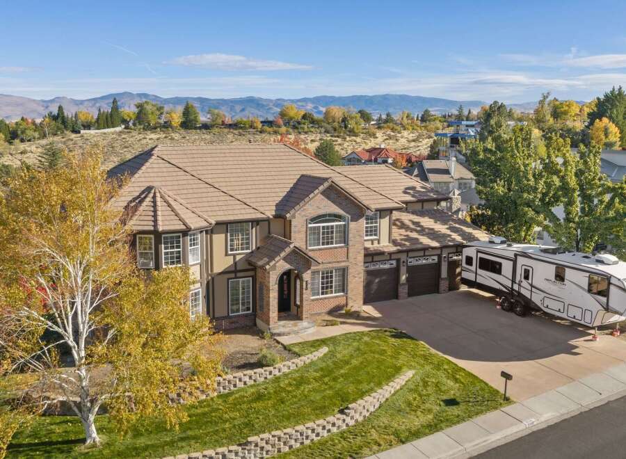 Experience luxury living in this stunning multi-story home, boasting a warm stucco and brick exterior complemented by a durable tile roof.