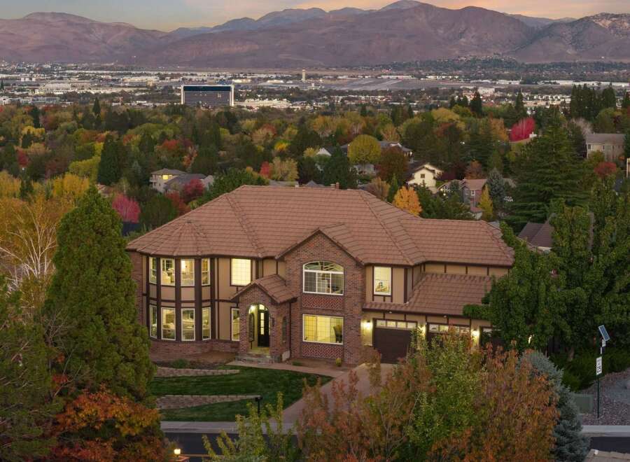 Experience luxury living in this stunning multi-story home, nestled amidst vibrant autumn foliage.