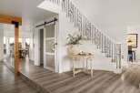 Step into a grand foyer featuring a stunning staircase with ornate black railings and a modern sliding glass door.