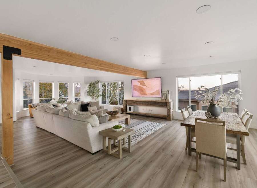 Experience modern living in this spacious open-concept home, featuring a large sectional sofa perfect for gatherings and a stylish dining area for family meals.