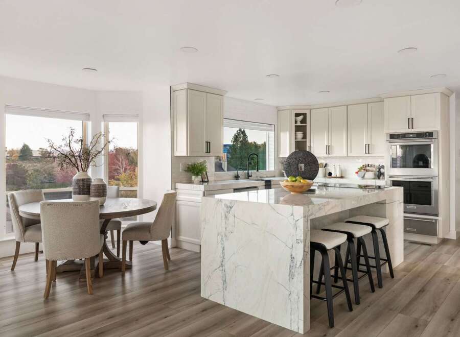This spacious kitchen boasts a stunning marble island with comfortable bar stools, perfect for casual dining or entertaining.
