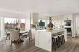 This spacious kitchen boasts a stunning marble island with comfortable bar stools, perfect for casual dining or entertaining.