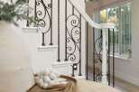 Elevate your home's aesthetic with this stunning staircase featuring elegant wrought iron balusters and a crisp white handrail.