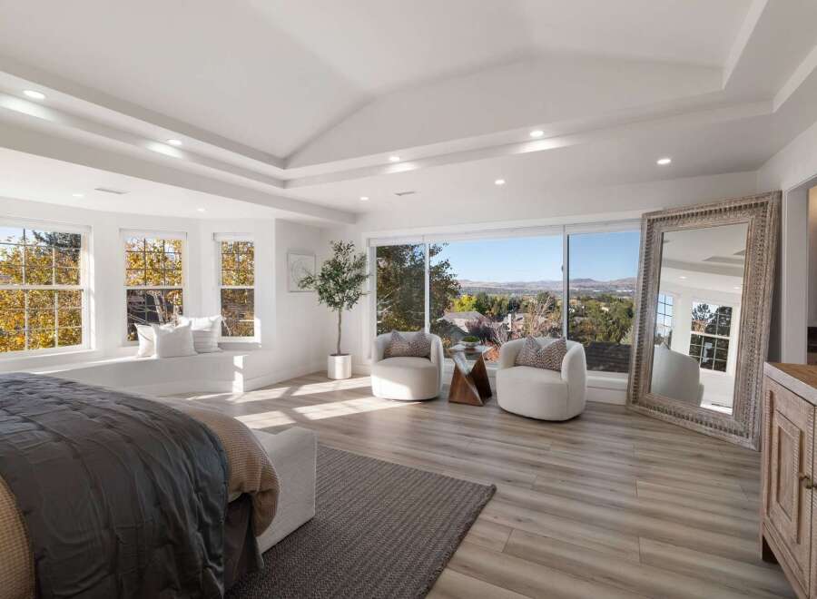 Experience breathtaking panoramic views from this luxurious master suite, featuring a spacious bay window with a built-in seating area perfect for enjoying the scenery.
