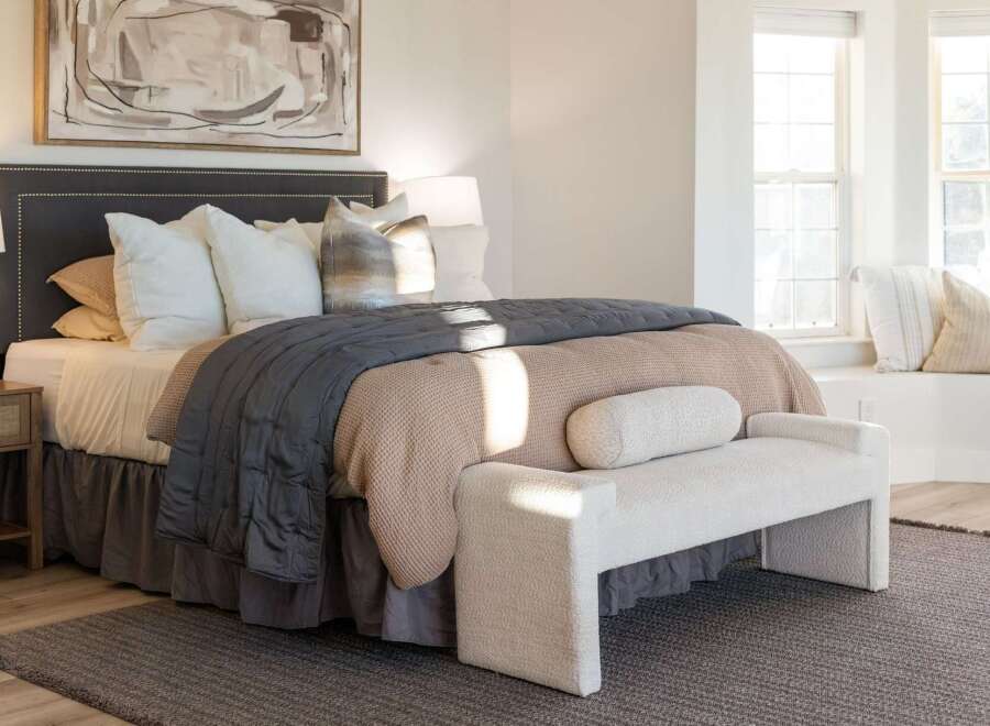 Experience ultimate comfort and style in this beautifully appointed bedroom, featuring a plush king-size bed adorned with luxurious linens and decorative pillows.