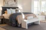 Experience ultimate comfort and style in this beautifully appointed bedroom, featuring a plush king-size bed adorned with luxurious linens and decorative pillows.