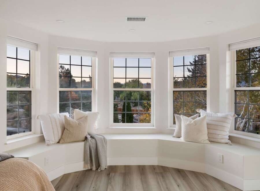 This spacious bay window offers a cozy seating area with plush pillows and a soft throw blanket, perfect for enjoying the scenic views.