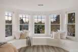 This spacious bay window offers a cozy seating area with plush pillows and a soft throw blanket, perfect for enjoying the scenic views.