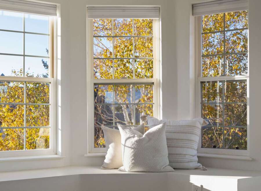 Bathed in natural light, this inviting window seat offers a serene spot to enjoy the vibrant autumn foliage.