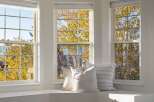 Bathed in natural light, this inviting window seat offers a serene spot to enjoy the vibrant autumn foliage.