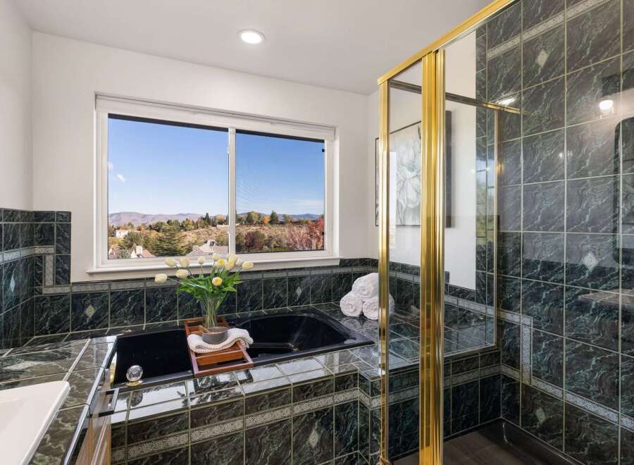 Indulge in relaxation with this luxurious bathroom featuring a deep soaking tub and a separate glass-enclosed shower.