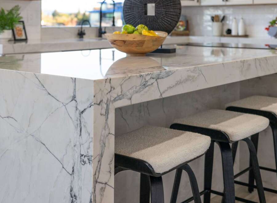 Experience luxury in this modern kitchen, featuring a stunning waterfall island with dramatic veining.