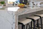 Experience luxury in this modern kitchen, featuring a stunning waterfall island with dramatic veining.