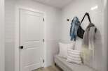 This entryway features a modern white door with a black knob, complemented by white subway tile walls.