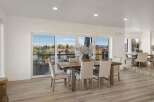 Experience breathtaking views from this stunning dining area, featuring a rustic wooden table and comfortable upholstered chairs.