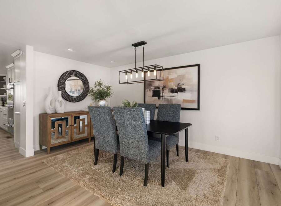 This elegant dining room features a sleek black dining table with four upholstered chairs, perfect for intimate gatherings.
