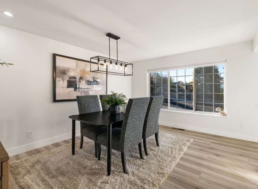 This dining room features a sleek black dining table with four upholstered chairs, perfect for intimate gatherings.