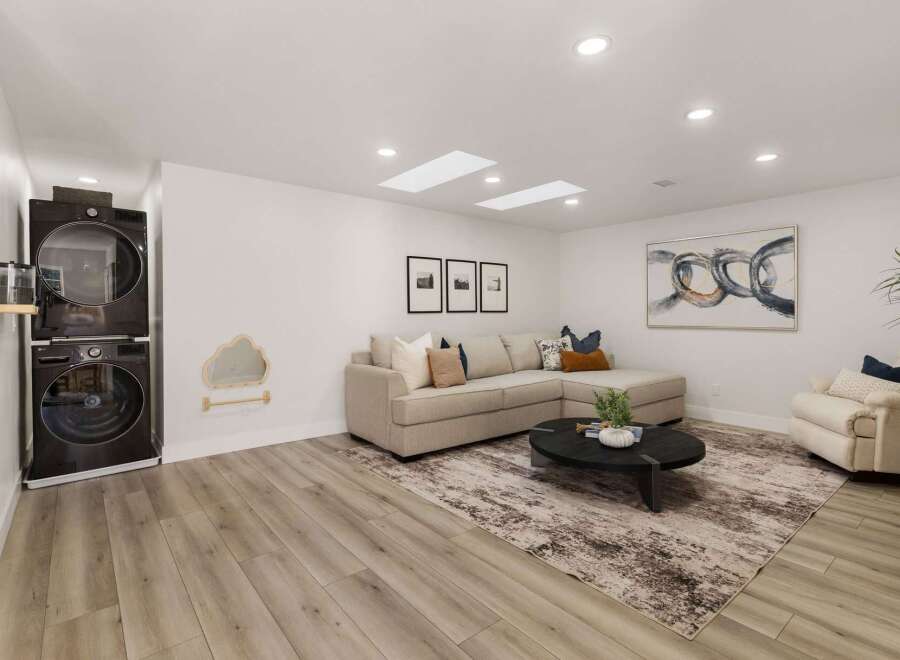 This modern living space seamlessly blends functionality with style, featuring a stacked washer and dryer unit for convenience.