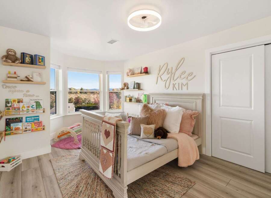 This charming nursery features a cozy crib and a comfortable bed, perfect for a growing child.