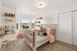 This charming nursery features a cozy crib and a comfortable bed, perfect for a growing child.