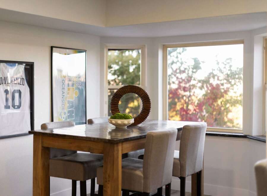 This dining area features a stylish wooden table with a stone top, complemented by upholstered chairs.