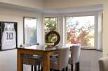 This dining area features a stylish wooden table with a stone top, complemented by upholstered chairs.