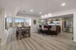 This spacious basement features a modern dining area with a wooden table and bar stools, perfect for casual meals or entertaining guests.
