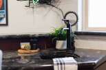 This modern bathroom features a sleek black faucet and a granite countertop, adding a touch of sophistication.