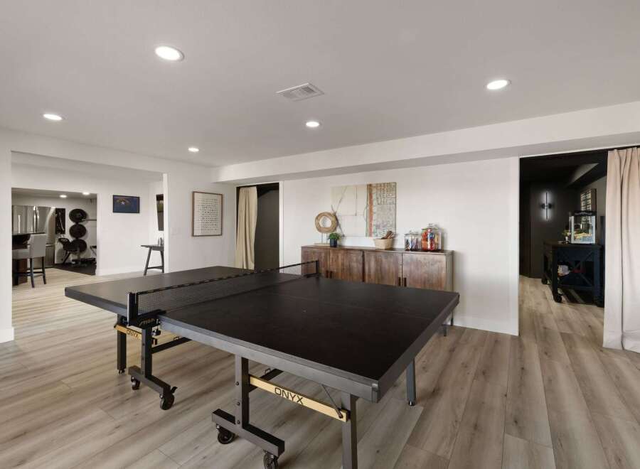 This spacious recreational room features a full-size ping pong table, perfect for friendly competition.