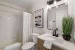 This modern bathroom features a clean white tiled shower and tub combo, complemented by a white fabric shower curtain.
