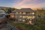 This stunning multi-level home boasts an expansive backyard perfect for entertaining, featuring multiple decks and a covered outdoor kitchen area.
