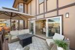 Enjoy outdoor living on this spacious deck, complete with a comfortable seating area and a modern fire pit table.