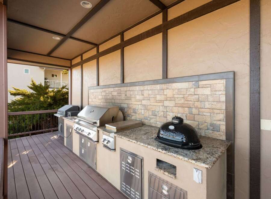Elevate your outdoor living with this luxurious covered patio, featuring a fully equipped gourmet grilling station.