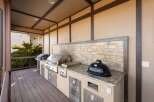 Elevate your outdoor living with this luxurious covered patio, featuring a fully equipped gourmet grilling station.