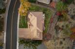 Experience luxury living in this stunning aerial view of a spacious home featuring a large, well-maintained lawn and a paved driveway.