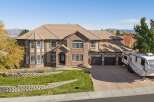 This stunning multi-story home boasts a beautiful brick and stucco exterior, complemented by a tile roof and numerous large windows that allow for ample natural light.