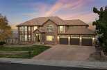 This stunning multi-story home boasts a beautiful brick and stucco exterior, complemented by a warm, earthy color palette and a classic tile roof.