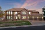 This stunning two-story home boasts a striking architectural design with a combination of brick and stucco exterior, complemented by a warm, inviting color palette.